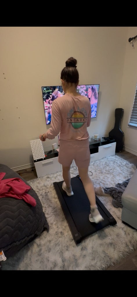 Walking on a walking pad at home while watching TV